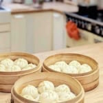 three layers of bamboo steamer baskets with bao buns in them with overlay text that says bamboo steamer guide.