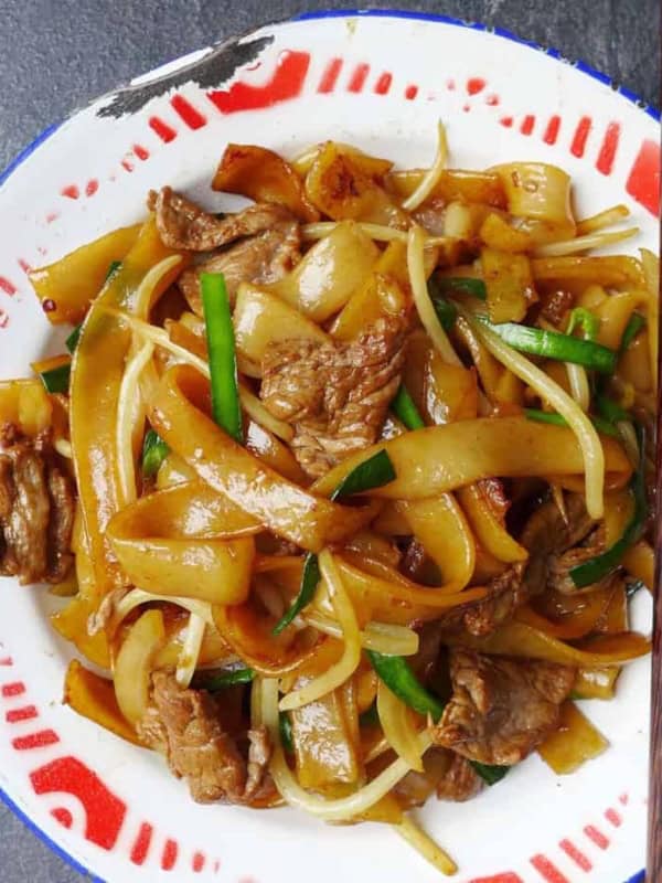 a plate of stir fried rice noodles with beef