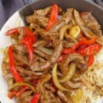 stir-fried beef with pepper and onion with overlay text that says black pepper beef.