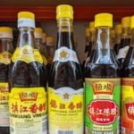 bottles of Chinkiang vinegar with overlay text that says rice vinegar guide.