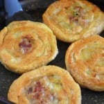 four beef stuffed flatbread in a skillet.
