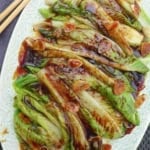 a plate of blanched lettuce with sauce and garlic with overlay text that says oyster sauce lettuce.