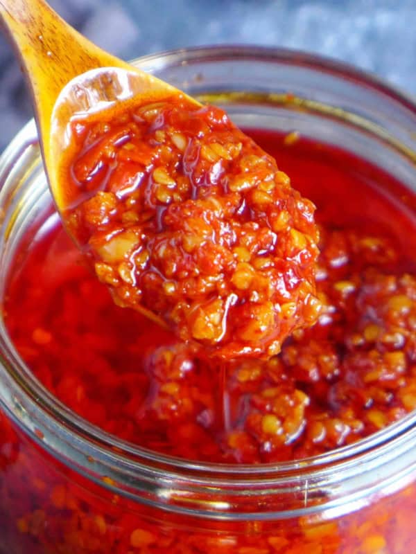 scooping out chiu chow chili oil from a jar.