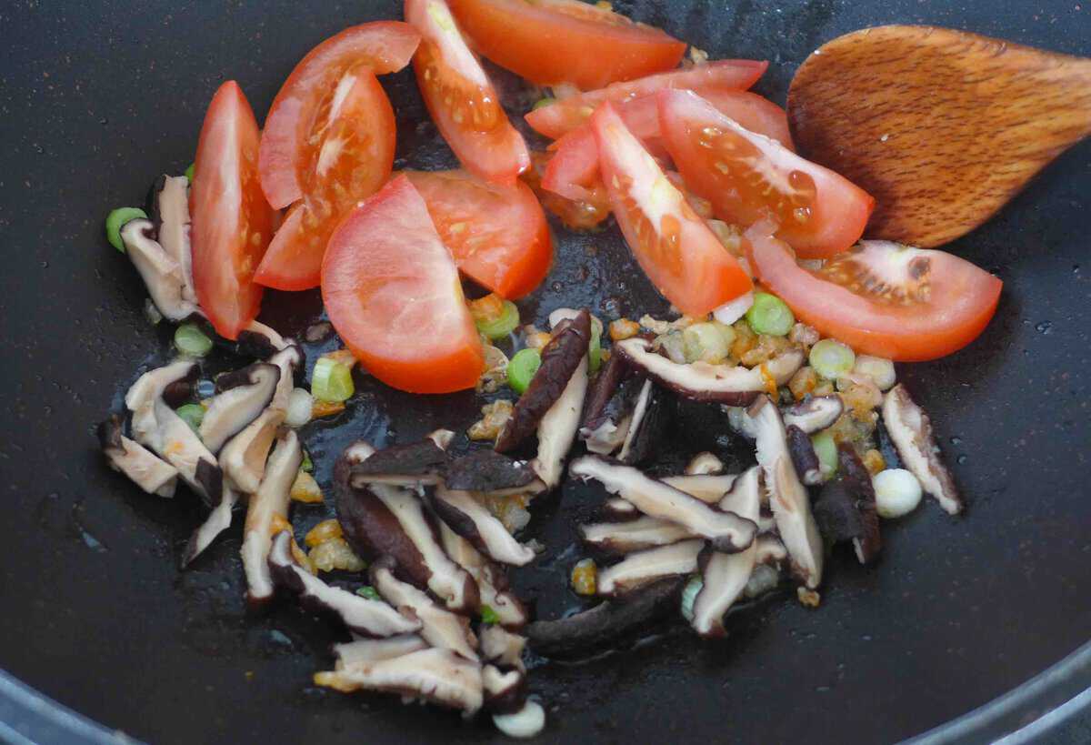 frying tomato and mushrooms.