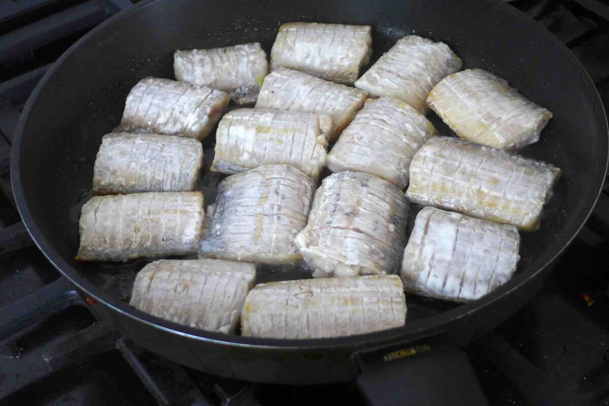 putting belt fish into a skillet.
