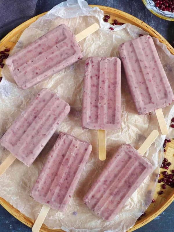 six red bean popsicles on a tray.