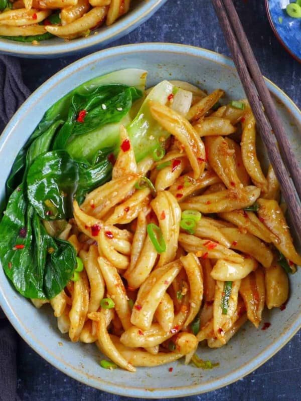 A bowls of scissor cut noodles with Bok Choy