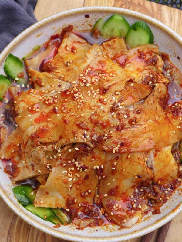 slices of pork over cucumber in a spicy dressing.