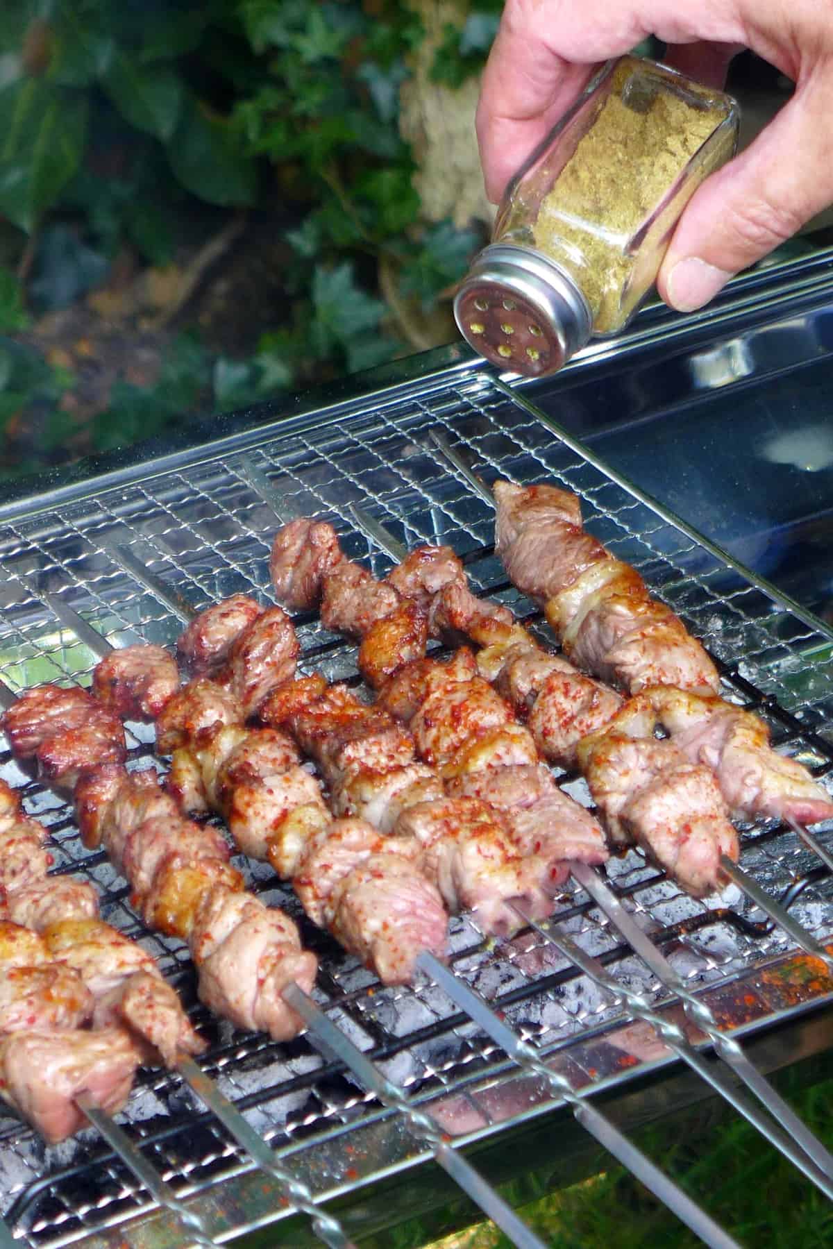 Sprinkle cumin powder over lamb skewers
